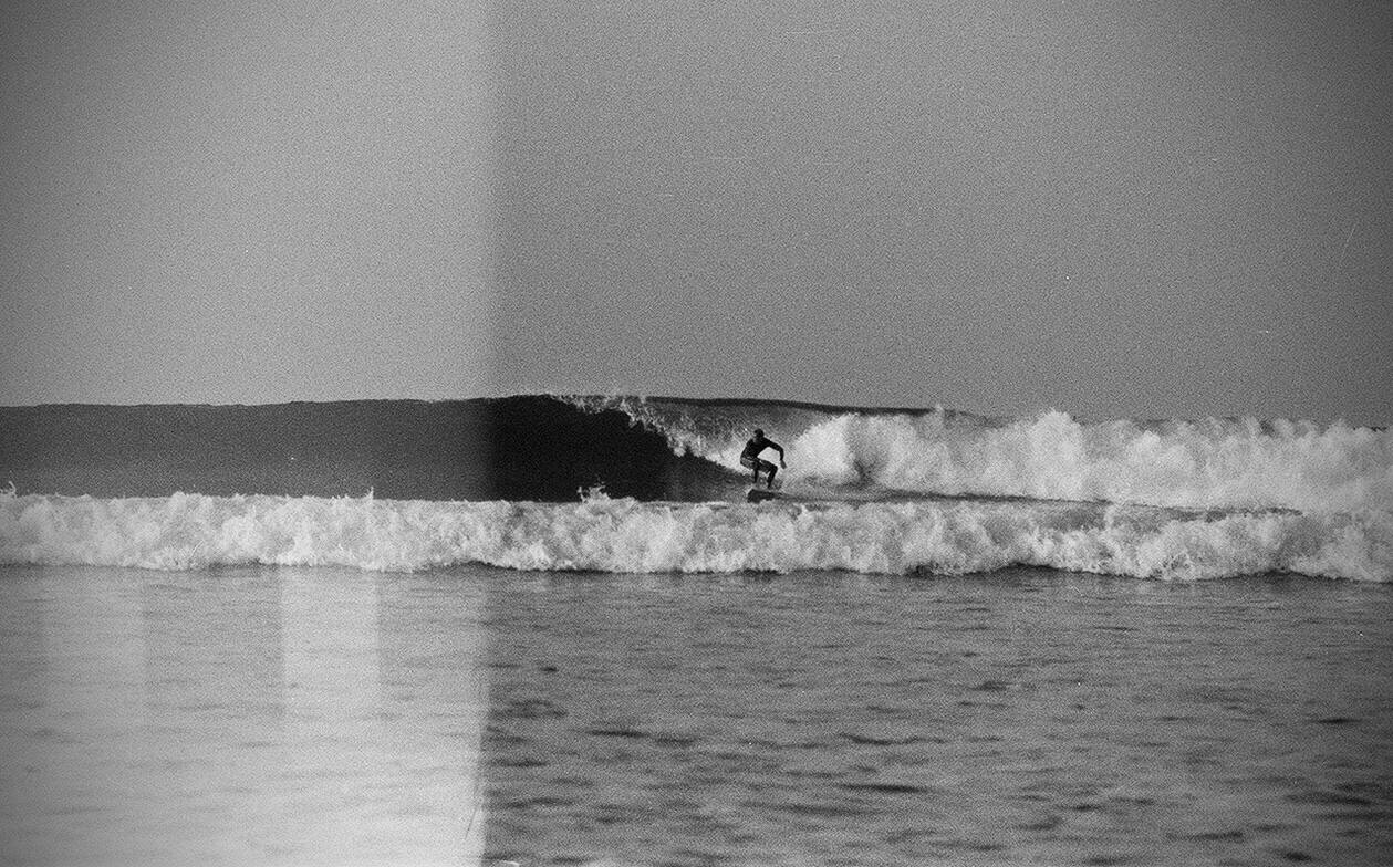 Тони с доской для серфа на пляже