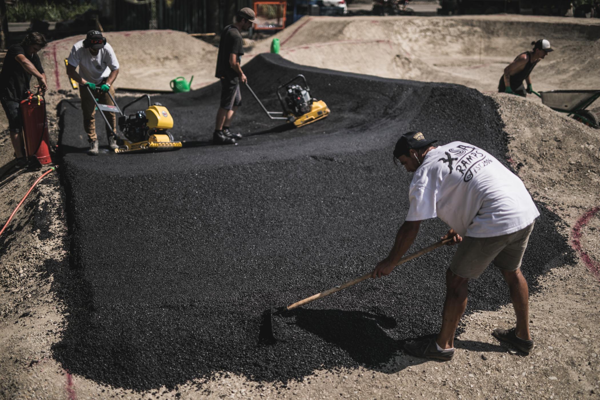 строители выравнивают асфальт на памптреке